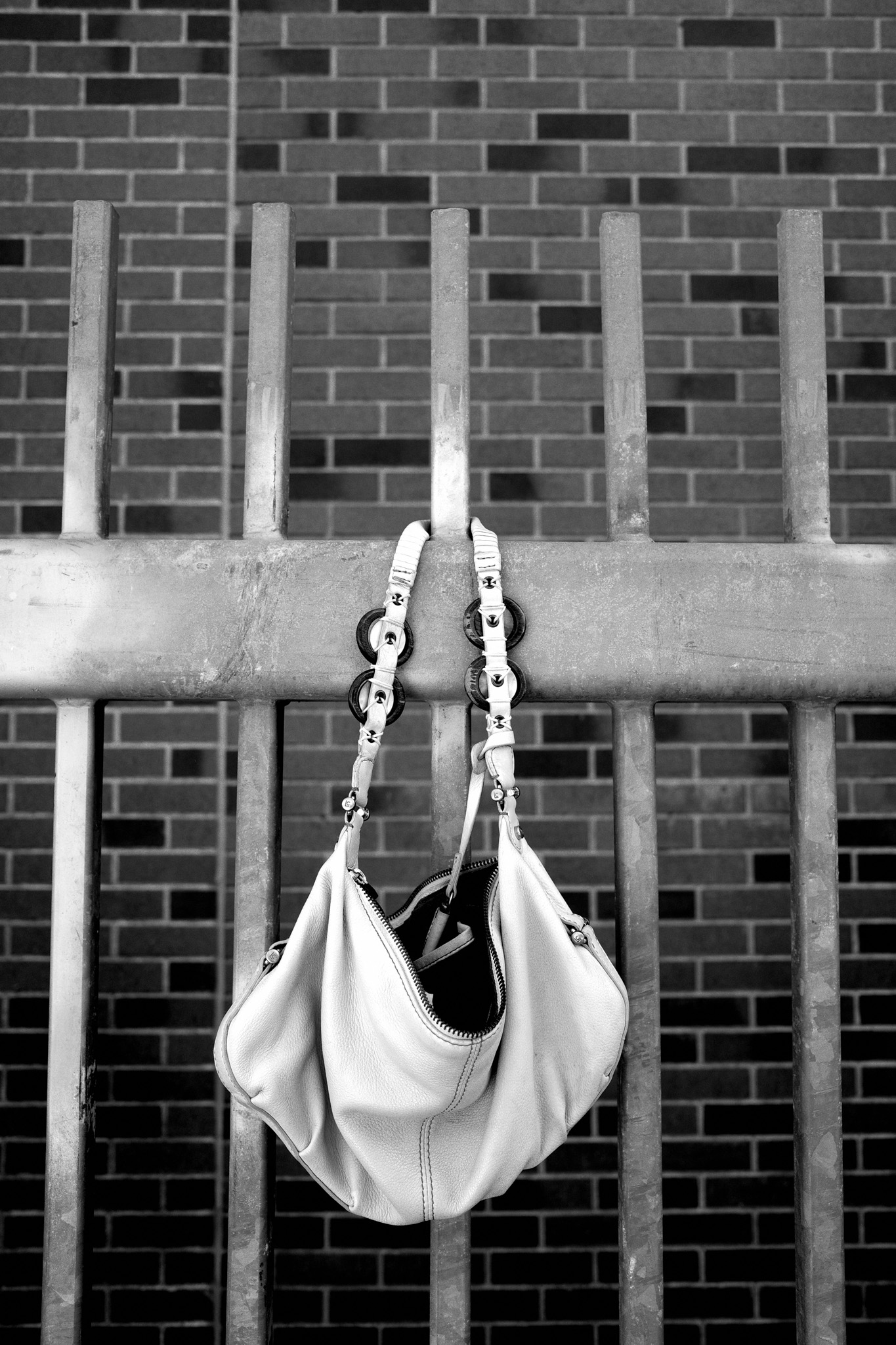 A purse hangs on the fence outside of the stadium