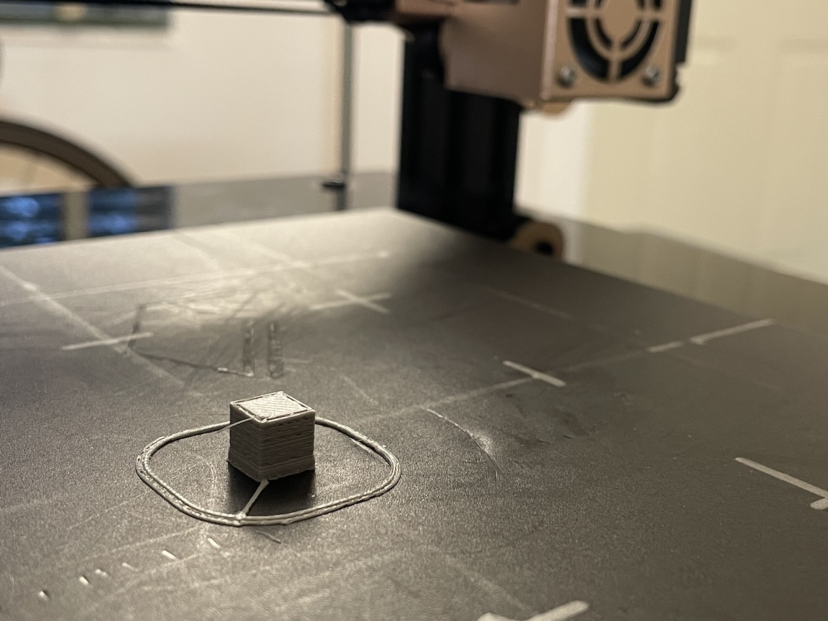 Small gray 3D printed calibration cube from a first test print
