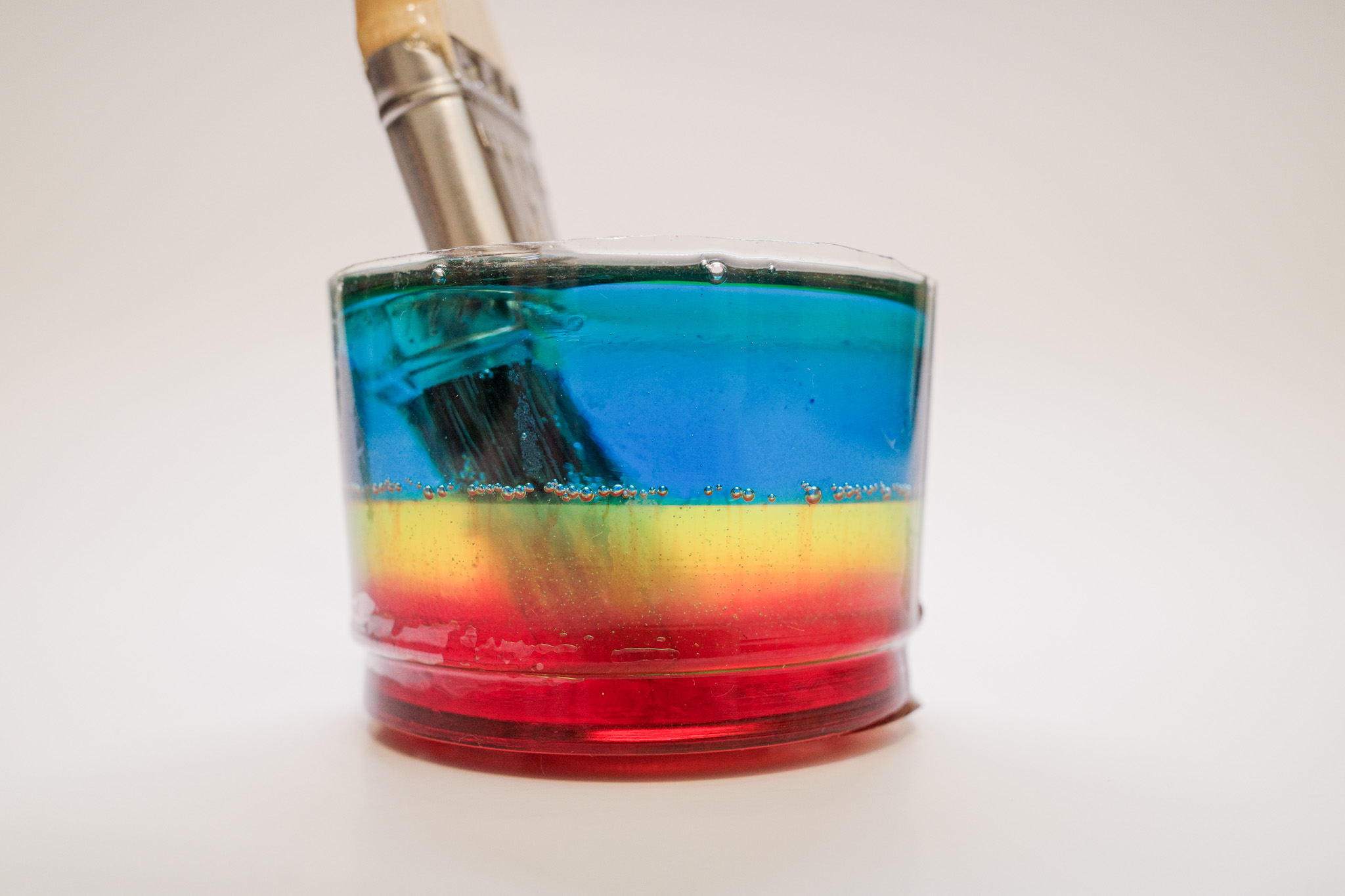 Vibrant paperweight featuring a paintbrush suspended in epoxy, crafted by artist Michael Frommer.